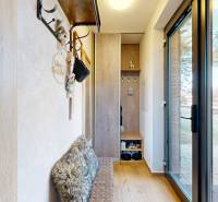 In the recreational apartment, there is an entrance hall with a wooden decor floor and glass doors.