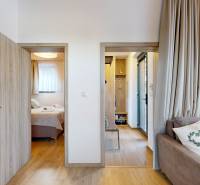 Recreational apartment with wood-decor flooring, a sofa, and access to the bedroom.