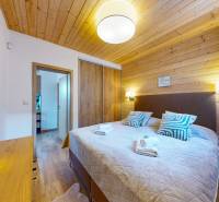 Recreational apartment with a bed, decorative pillows, and a wooden decor floor.