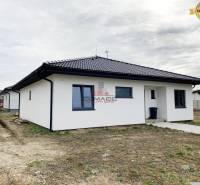 A family house on a street in Nové Mesto nad Váhom with a white facade and a dark roof.