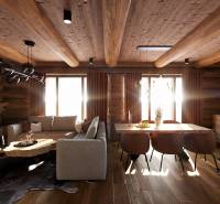 Wooden interior with wood-patterned flooring, sofa, and table, house construction.