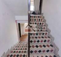 A staircase with colorful tiles in a family house, light and traditional design.