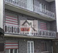 A three-story family house in Studená with balconies and paving stones in the yard.