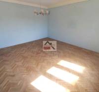 A room in a family house with blue walls and a floor with a wooden decor.