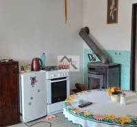The interior of a family house with a tile stove, a television, and a dining table.