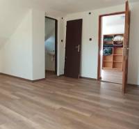 The attic of the cottage with a wooden decor floor and built-in cabinets.