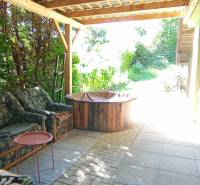 Covered terrace of the cottage in Ružiná with a seating set and surrounding greenery.