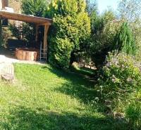 The greenery around the cottage in Ružiná, a beautiful garden and a wooden pergola.