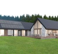 Stone house in Tajov with photovoltaic panels on the roof, surrounded by forest. Development plots.