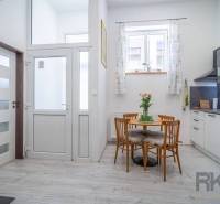 A bright kitchen with a wooden table, chairs, a plant, and modern equipment in a 4-room apartment.