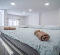 A bright bedroom with a comfortable bed, softly coordinated textiles, a window facing Hviezdoslavova Street.