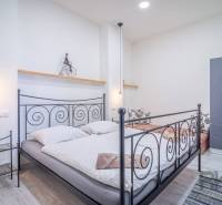 Bedroom with a metal bed and wardrobe in a 4-room apartment on Hviezdoslavova Street.