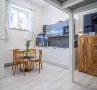 Bright kitchen with a dining table, wooden furniture, in a 4-room apartment near Hviezdoslavova Street.