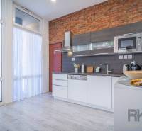 A kitchen in a 4-room apartment with a brick wall, modern appliances, on Hviezdoslavova Street.