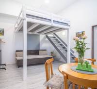 Interior with wooden furniture and a raised bed on Hviezdoslavova Street, suitable for a 4-room apartment.