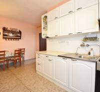 A kitchen in a family house with white cabinets and a dining nook.