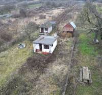 A rural plot with a cottage and trees in the vineyards in Nána for sale.