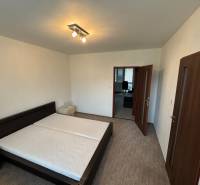Bedroom in a 2-room apartment with a bed and nightstands, entrance to another room.