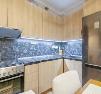 Kitchen in a 2-room apartment, wooden decor, marble countertop, stainless steel appliances.