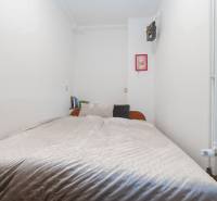 A cozy bedroom in a 2-room apartment with decorative elements and books on the table.