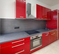 A kitchen in a 4-room apartment with red cabinets and modern appliances.