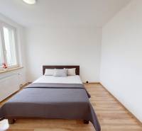 A bedroom with a bed and a wooden decor floor in a 4-room apartment.