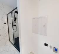 A bathroom in a 4-room apartment with marble tiles and a shower corner.
