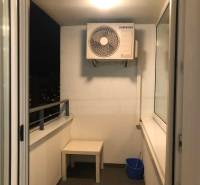 Balcony in a 2-room apartment with air conditioning, a table, and a cleaning bucket.