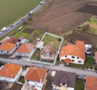 Aerial view of a row of family houses in Nadlice near the road and field.