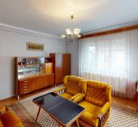 Living room in a family house with retro furniture and velvet armchairs, floor with wooden decor.