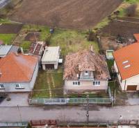 Family houses in Nadlice with surrounding gardens, fields, and an access road.