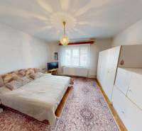 Bedroom with a double bed, white wardrobe, and carpet in a family house in Nadlice.
