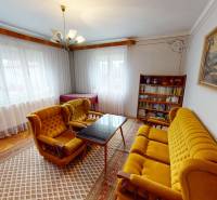 Living room with retro furniture and wood-patterned flooring in a family house.