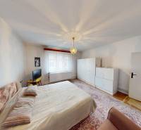 Bedroom in a family house with two cabinets and a TV on a table.