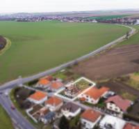A family house in Nadlice, surrounded by fields and other houses by the road.
