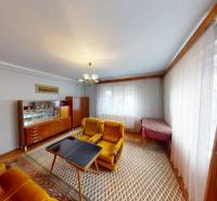 A living room in a family house with yellow armchairs and solid furniture.