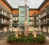 The courtyard in Oščadnica with a decorative column and modern apartments around.