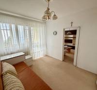 A room in a 3-room apartment with a bed, furniture, a large window, and curtains.