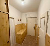 A hallway with built-in wardrobes and walls in a wooden decor in a 3-room apartment.