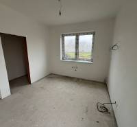 Empty room with white walls and visible wiring in a family house.