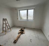 Empty room in a family house with a window, ladders, and construction materials.
