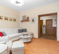 Living room with light-colored sofa seating and wood-patterned flooring in a 4-room apartment.