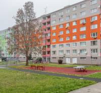 Apartment building with a colorful facade, playground, and benches on Poľnohospodárska Street, Bratislava - Vrakuňa.