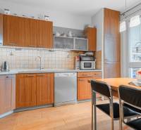 A kitchen with wooden cabinets and a wooden decor floor in a 4-room apartment.