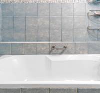 Blue bathroom with a bathtub and a holder in a 4-room apartment.