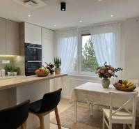 Bright kitchen in a 3-room apartment with a large window and a table, wood decor.