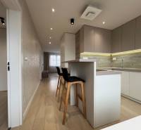 A kitchen with an island and a wooden decor floor in a 3-room apartment.