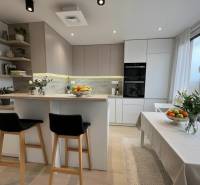 Kitchen in a 3-room apartment with an island, wooden decor flooring, and decorations.