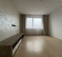 A room in a 3-room apartment with a floor featuring a wood decor and a window with curtains.