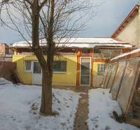 A family house on Garbiarska Street in Stará Ľubovňa with a snowy garden and a tree.